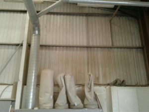 Photos showing before and after cleaning of warehouse walls and ceiling